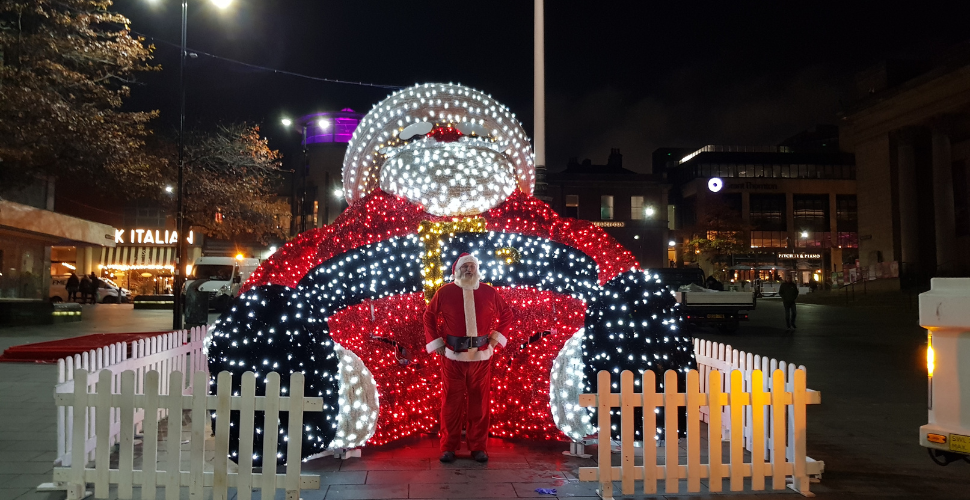 Giant Santa Claus Sculpture covered in multi-coloured lights on the waterfront in Plymouth 